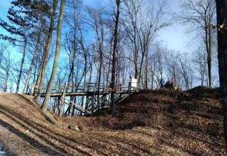 Medzi stromami sa črtajú múry Obišovského hradu a prístupový most
